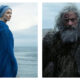 A side-by-side composite from the film 'The Death of Robin Hood'. On the left, Jodie Comer stands in profile wearing a vibrant blue hooded cloak and matching head covering, gazing out over a grey, overcast sea. On the right, a tight close-up reveals Hugh Jackman as a weathered Robin Hood with long, dishevelled grey hair, a thick beard, and facial scars, staring forward in a rugged fur cloak.